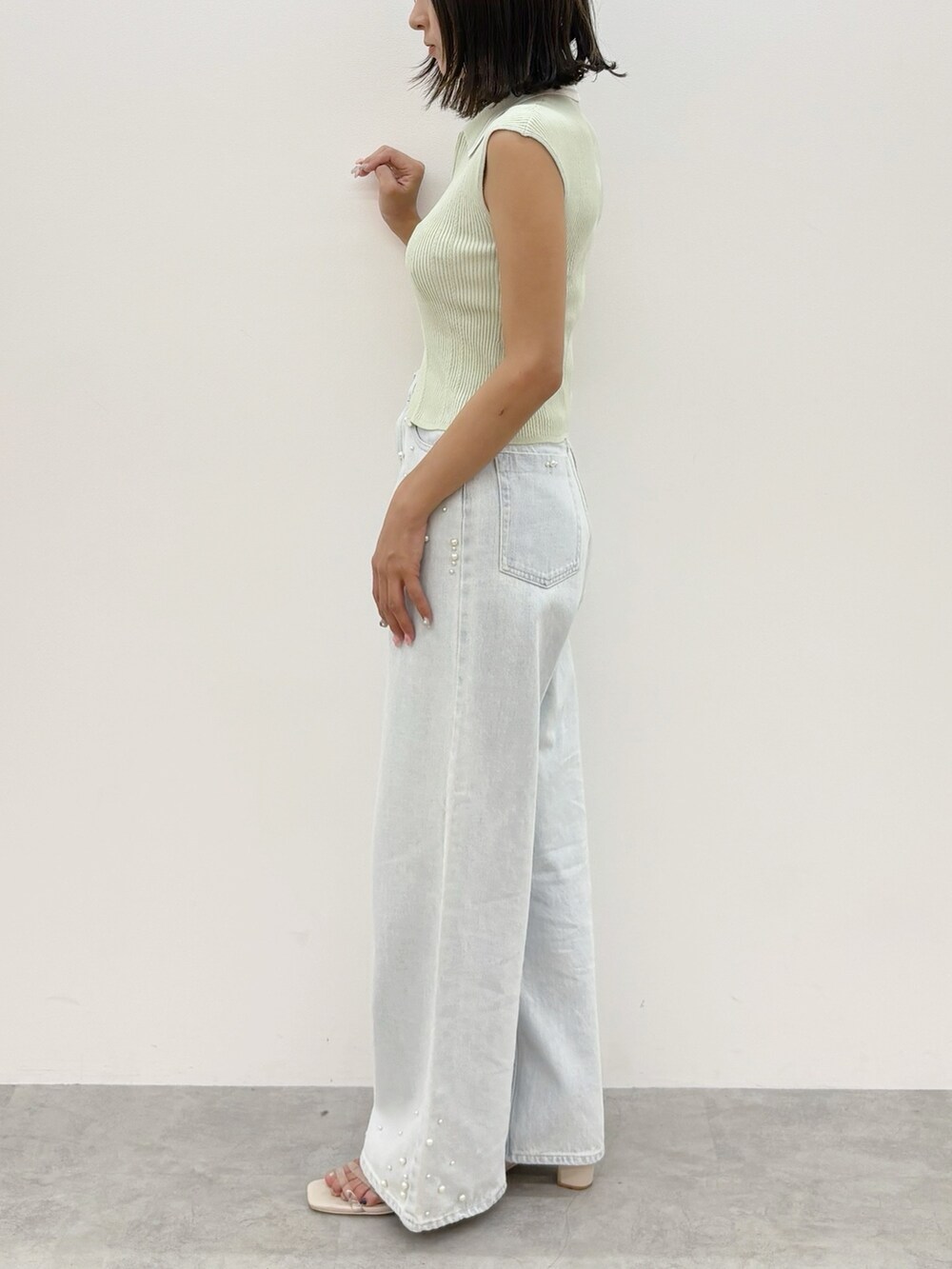 ブルー系のデニムパンツ、グリーン系のニット/セーターを着用したレディースの夏コーディネートの3枚目の写真