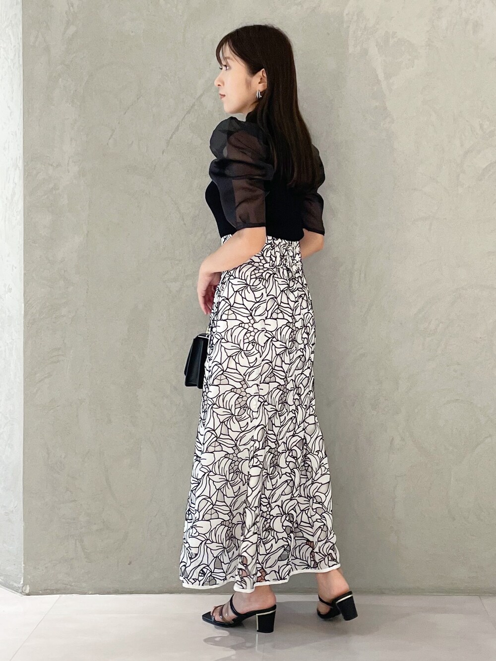 ホワイト系のスカート、ブラック系のサンダル、ブラック系のショルダーバッグを着用したレディースの夏コーディネートの4枚目の写真