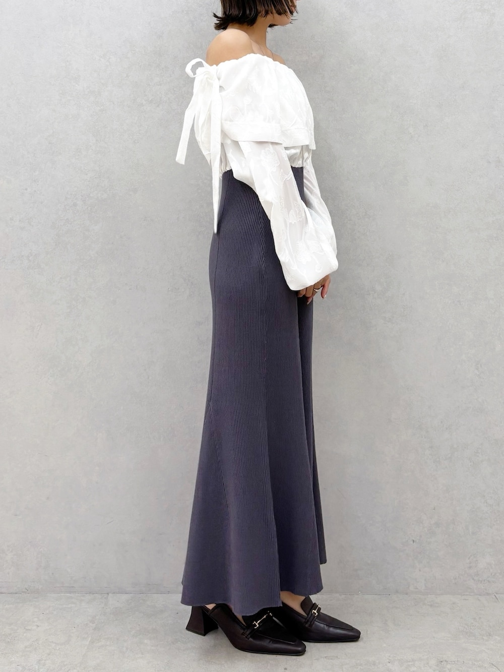 ブラウン系のパンプス、グレー系のワンピースを着用したレディースの冬コーディネートの6枚目の写真