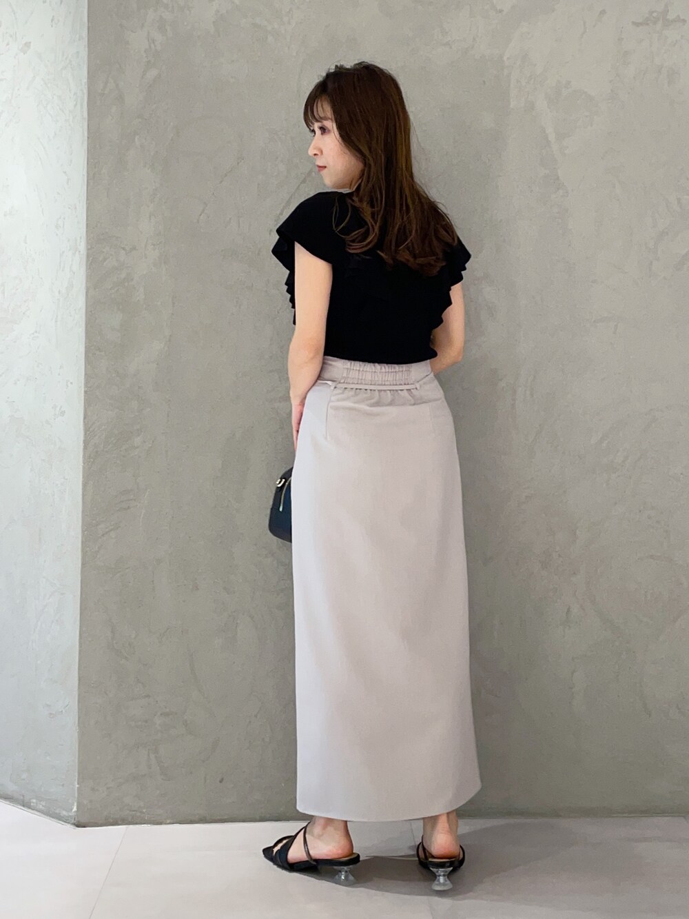 ブラック系のボストンバッグ、ブラック系のニット/セーター、ブラック系のサンダルを着用したレディースの春コーディネートの6枚目の写真