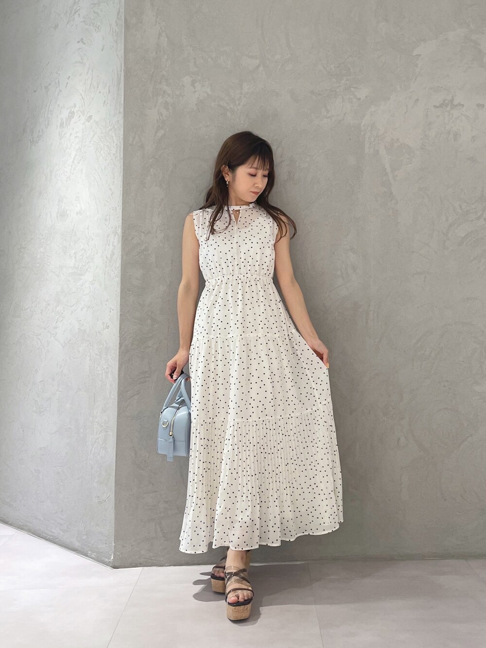 ホワイト系のワンピース、ブラック系のサンダル、ブルー系のボストンバッグを着用したレディースの夏コーディネートの5枚目の写真