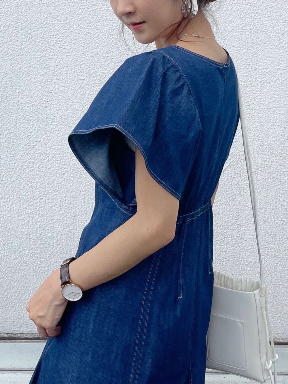 ブルー系のワンピース、ブラウン系のサンダル、ホワイト系のハンドバッグを着用したレディースの夏コーディネートの2枚目の写真