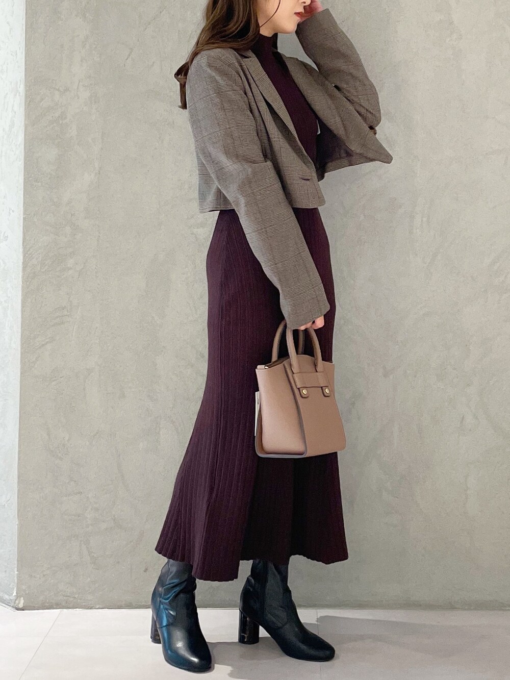 ブラウン系のワンピース、ブラック系のブーツ、ブラウン系のハンドバッグを着用したレディースの秋コーディネートの3枚目の写真