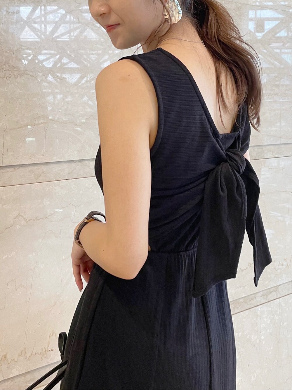 ブラック系のトートバッグ、ベージュ系のサンダルを着用したレディースの夏コーディネートの4枚目の写真