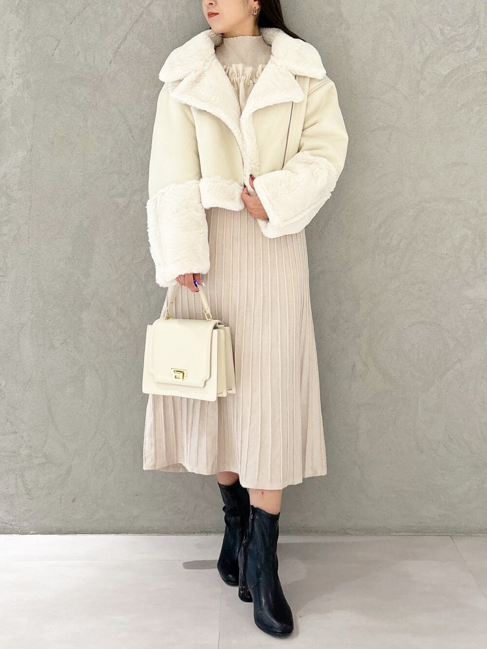 ホワイト系のワンピース、ブラック系のブーツ、ホワイト系のハンドバッグを着用したレディースの秋コーディネートの7枚目の写真