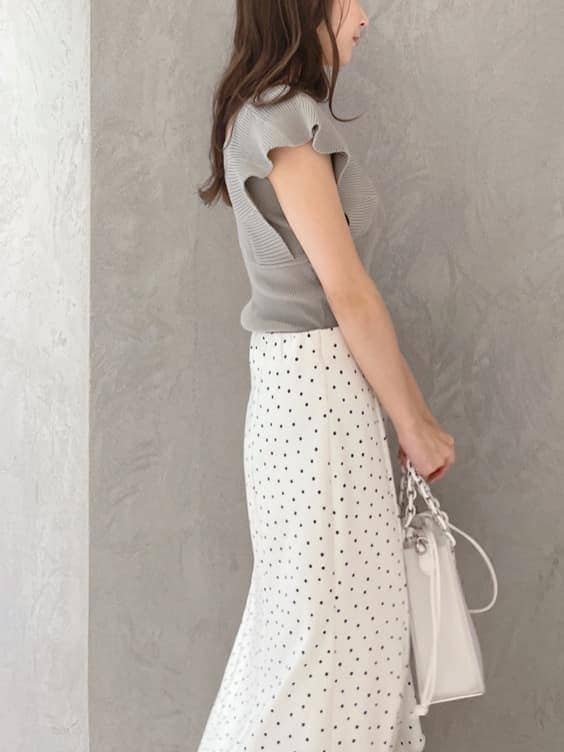 ホワイト系のハンドバッグ、グリーン系のサンダル、ホワイト系のスカートを着用したレディースの春コーディネートの6枚目の写真