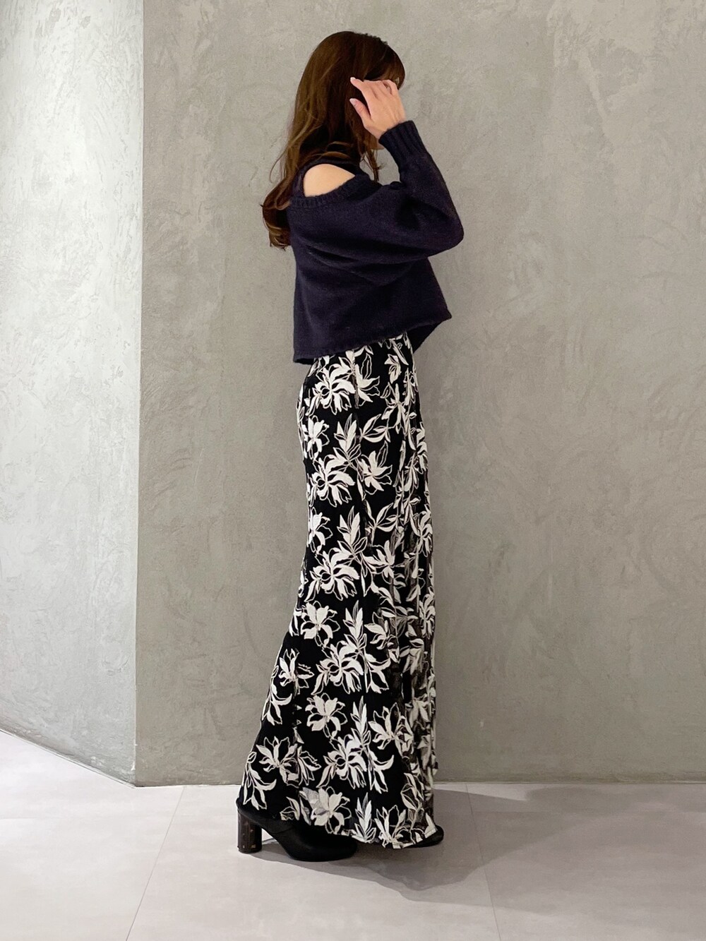 ブルー系のスカート、グレー系のニット/セーターを着用したレディースの秋コーディネートの2枚目の写真