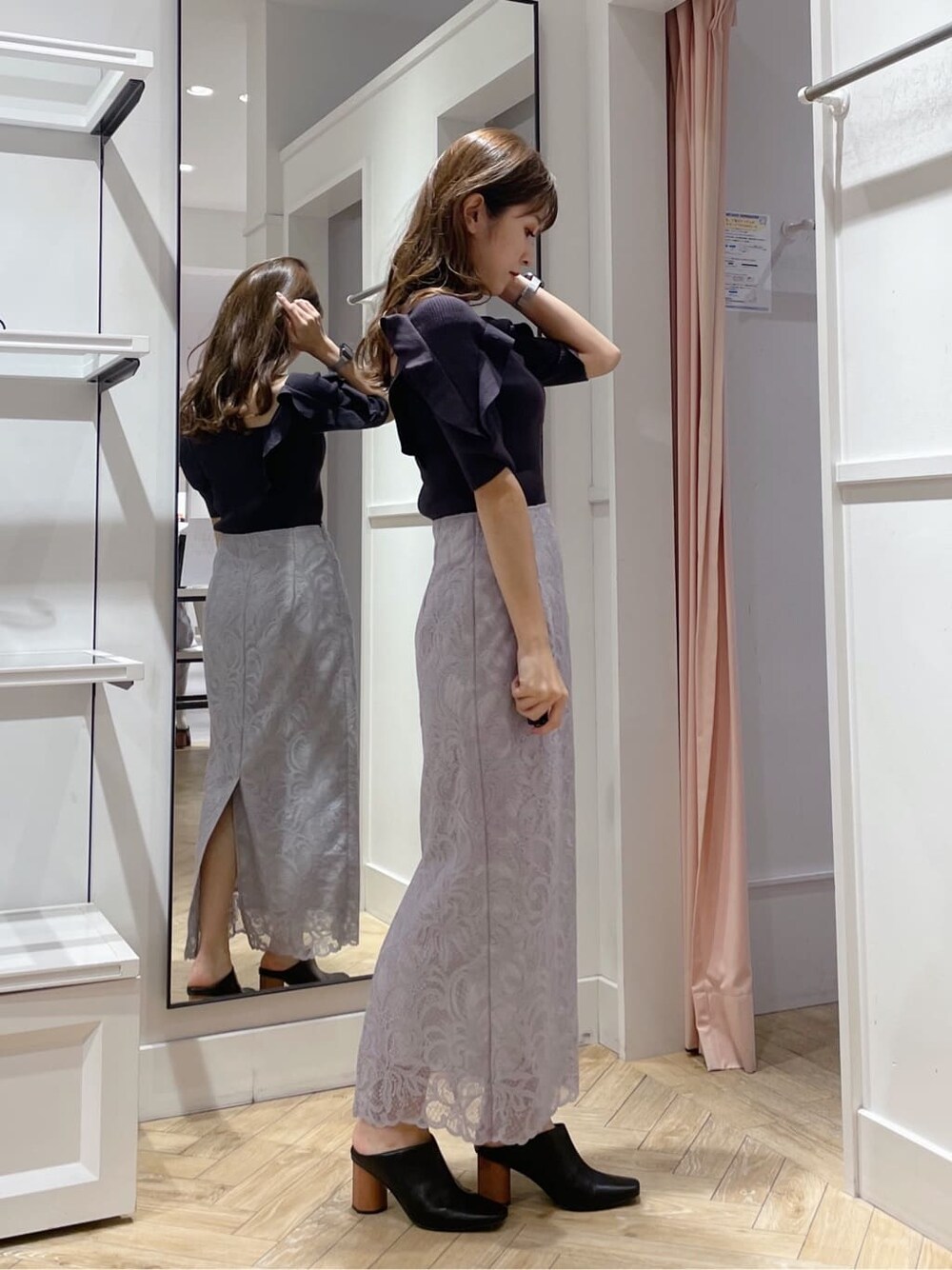 グレー系のスカート、ブラック系のサンダル、ブラウン系のニット/セーターを着用したレディースの夏コーディネートの2枚目の写真