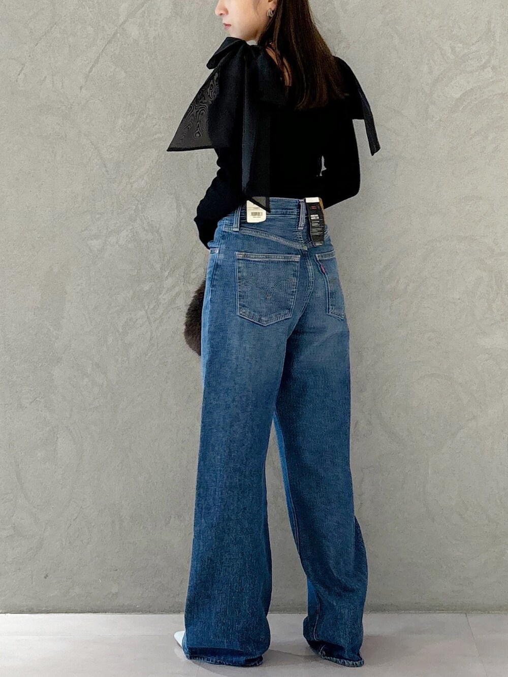 ブラウン系のハンドバッグ、シルバー系のパンプス、ブラック系のニット/セーターを着用したレディースの秋コーディネートの6枚目の写真