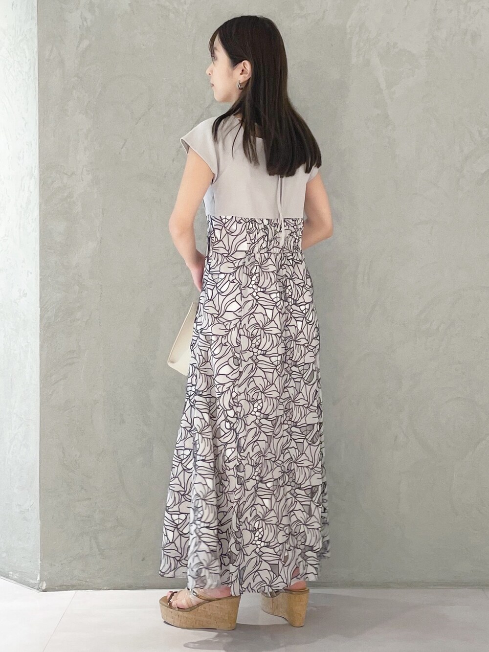 ホワイト系のショルダーバッグ、ブラウン系のサンダル、ベージュ系のワンピースを着用したレディースの春コーディネートの3枚目の写真