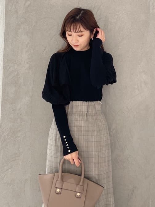 ブラウン系のハンドバッグ、グレー系のスカート、ブラック系のニット/セーターを着用したレディースの秋コーディネートの5枚目の写真