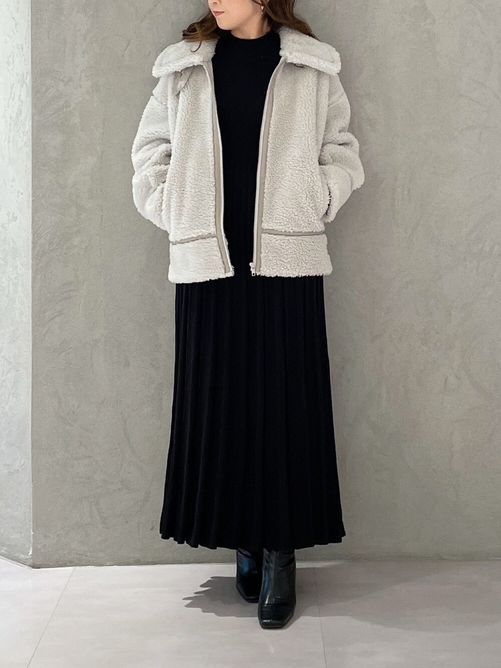 ブラック系のワンピース、ブラック系のブーツ、グレー系のその他アウターを着用したレディースの冬コーディネートの7枚目の写真