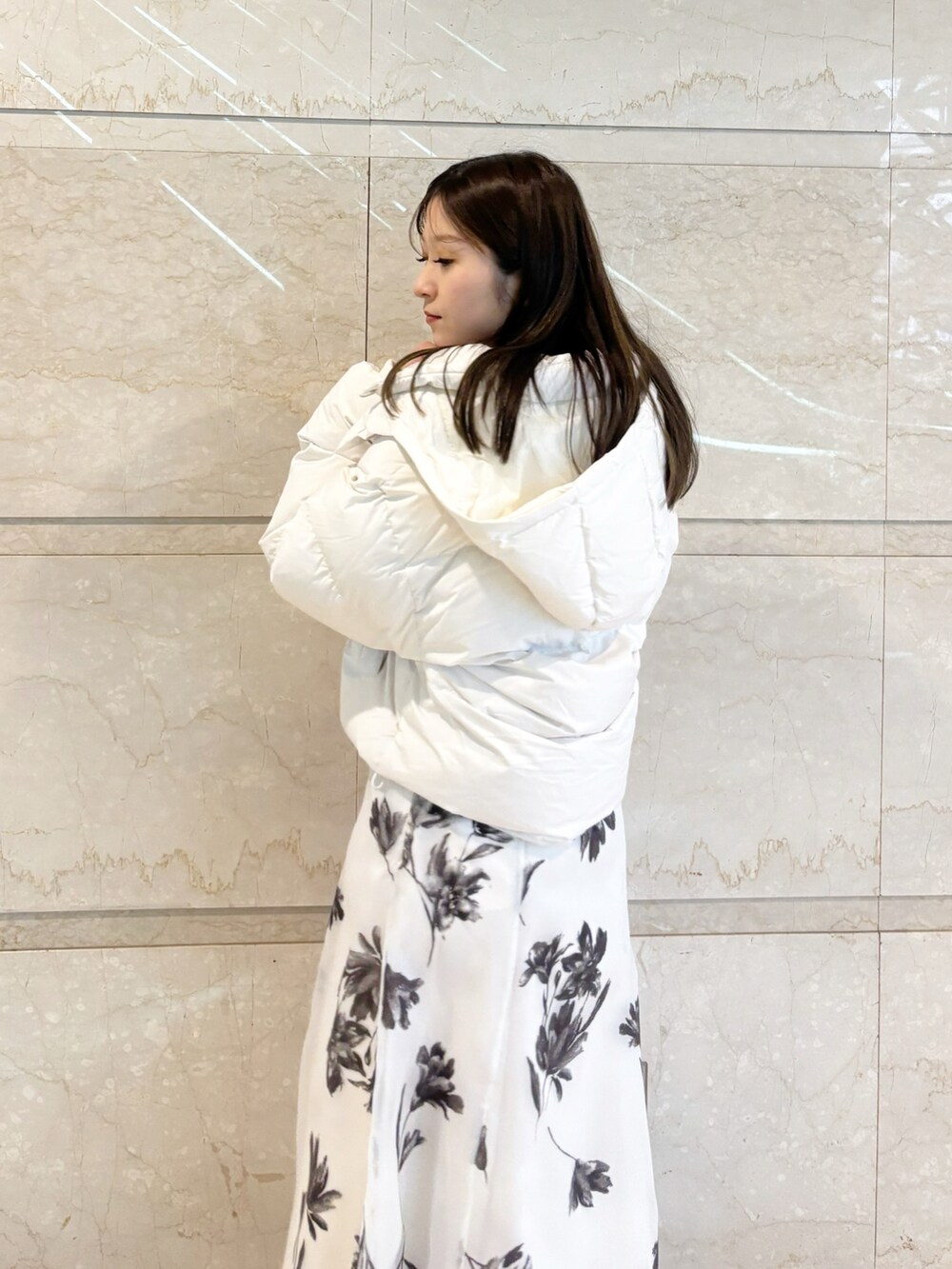 ホワイト系のスカート、ブラック系のブーツ、レッド系のカーディガン/ボレロを着用したレディースの冬コーディネートの6枚目の写真