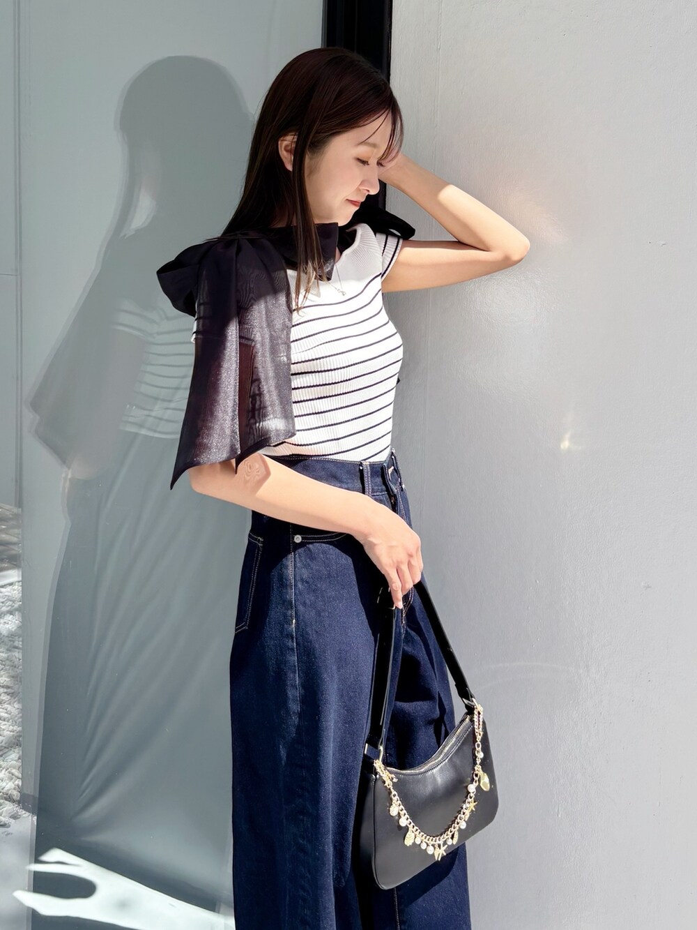 ブルー系のデニムパンツ、その他のニット/セーター、ホワイト系のサンダルを着用したレディースの夏コーディネートの3枚目の写真