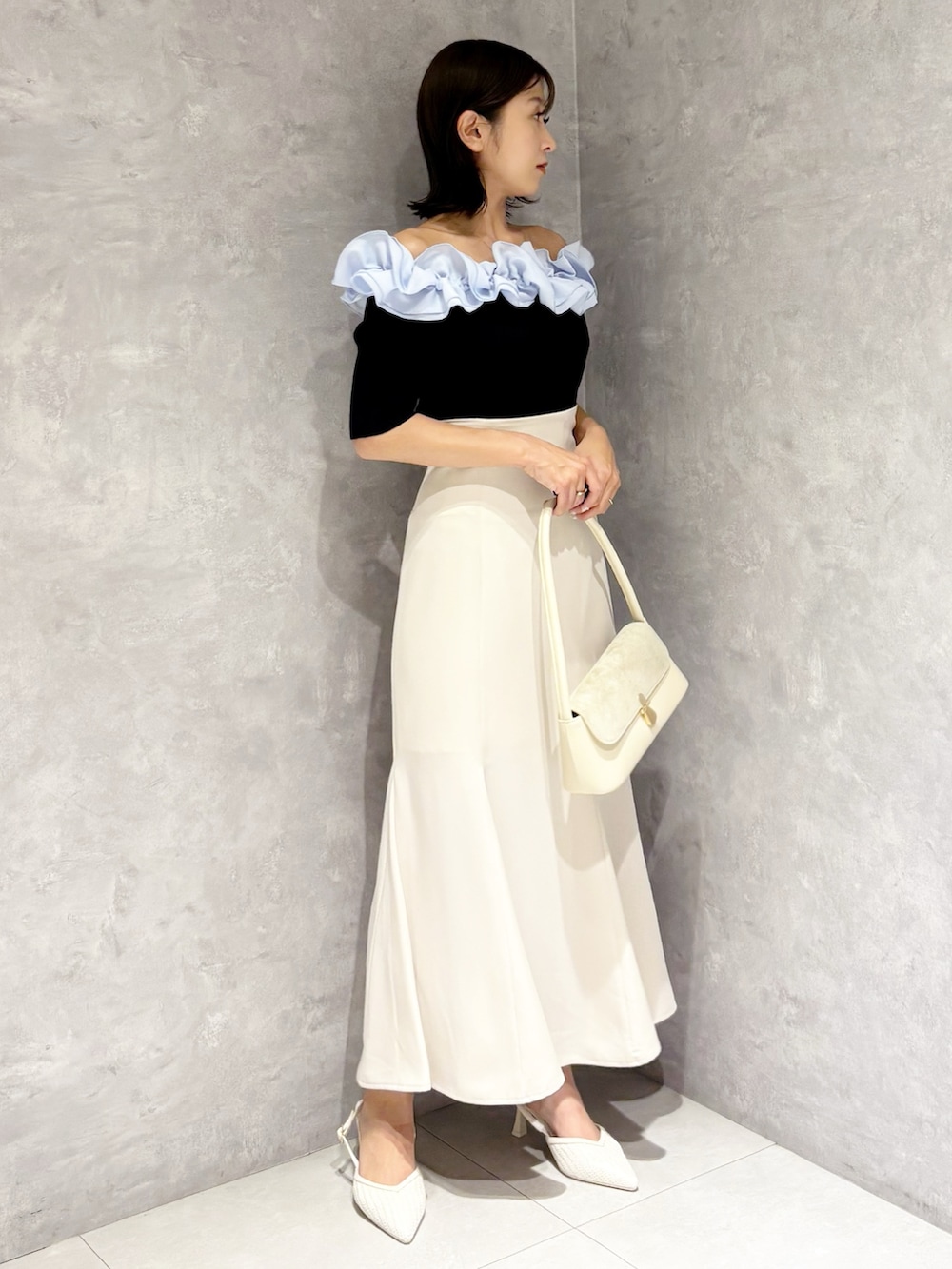 ホワイト系のスカート、ホワイト系のパンプス、ブルー系のニット/セーターを着用したレディースの春コーディネートの3枚目の写真