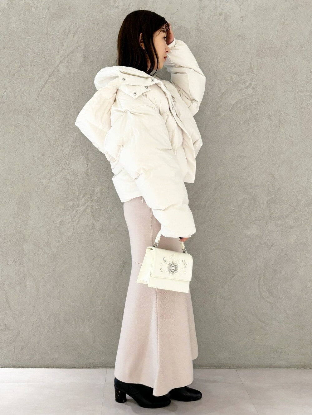 ピンク系のワンピース、ブラック系のブーツ、ホワイト系のショルダーバッグを着用したレディースの秋コーディネートの4枚目の写真