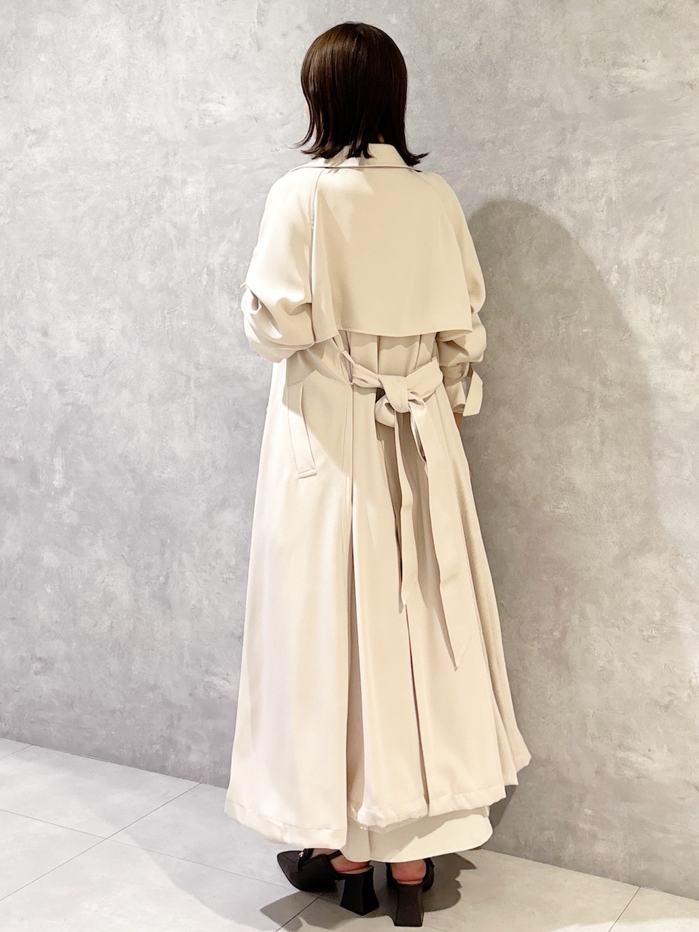 ホワイト系のスカート、ブラウン系のパンプス、ブラック系のニット/セーターを着用したレディースの春コーディネートの3枚目の写真