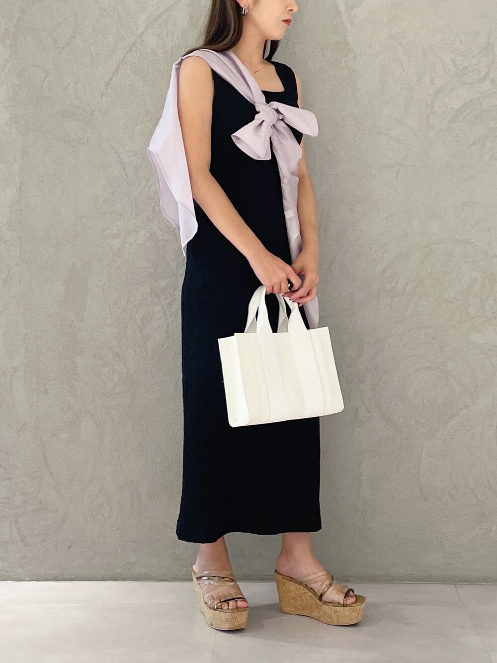 ピンク系のトートバッグ、ブラウン系のサンダル、ブラック系のワンピースを着用したレディースの夏コーディネートの2枚目の写真