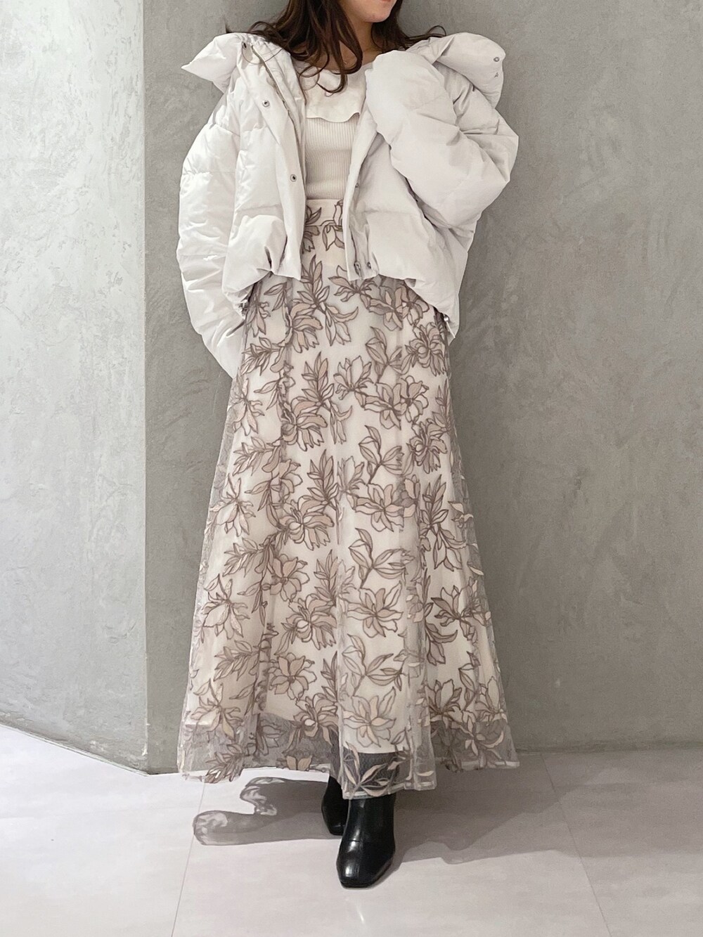 ホワイト系のダウンジャケット/コート、ホワイト系のニット/セーター、ピンク系のスカートを着用したレディースの冬コーディネートの4枚目の写真