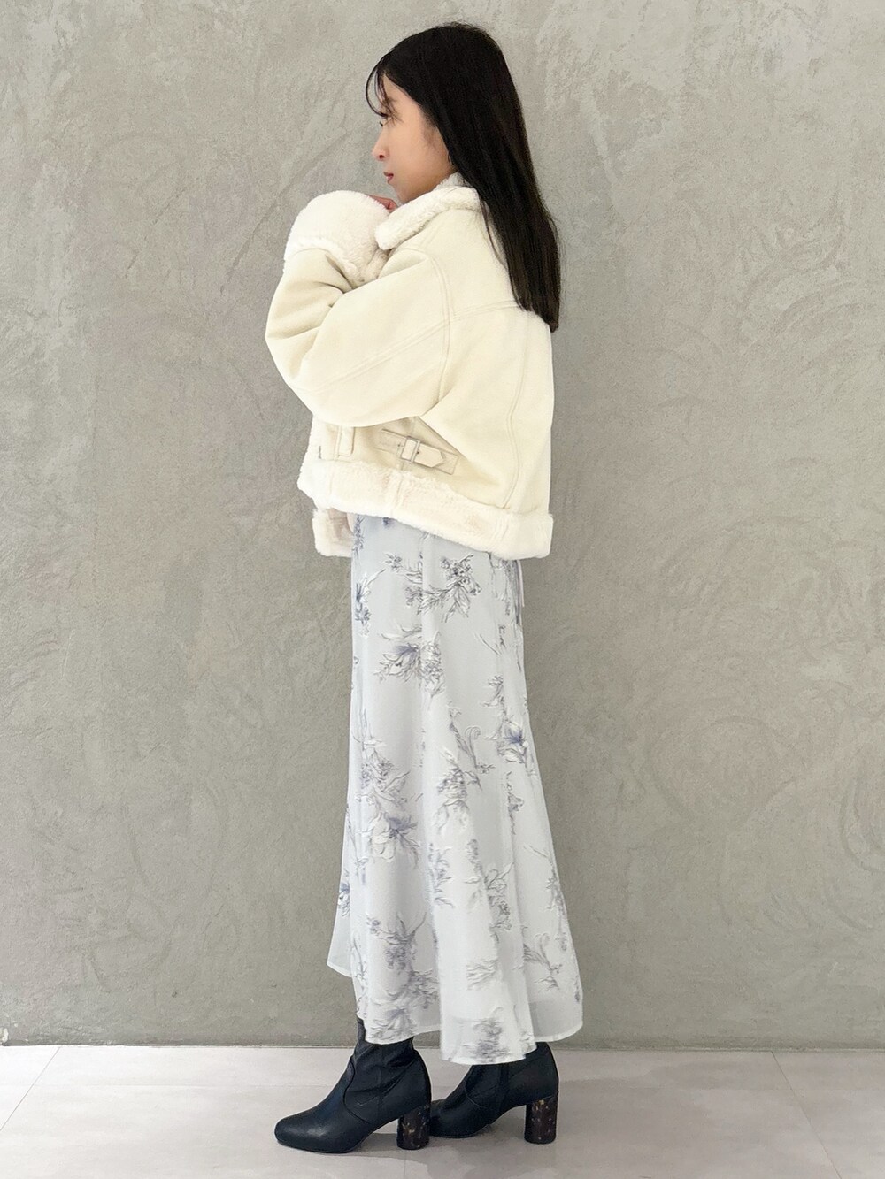 パープル系のワンピース、ブラック系のブーツ、ホワイト系のショルダーバッグを着用したレディースの秋コーディネートの2枚目の写真