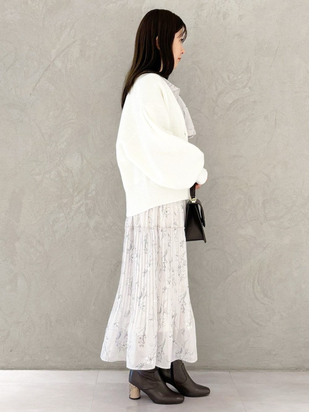 ピンク系のワンピース、ブラウン系のブーツ、ブラウン系のハンドバッグを着用したレディースの冬コーディネートの3枚目の写真