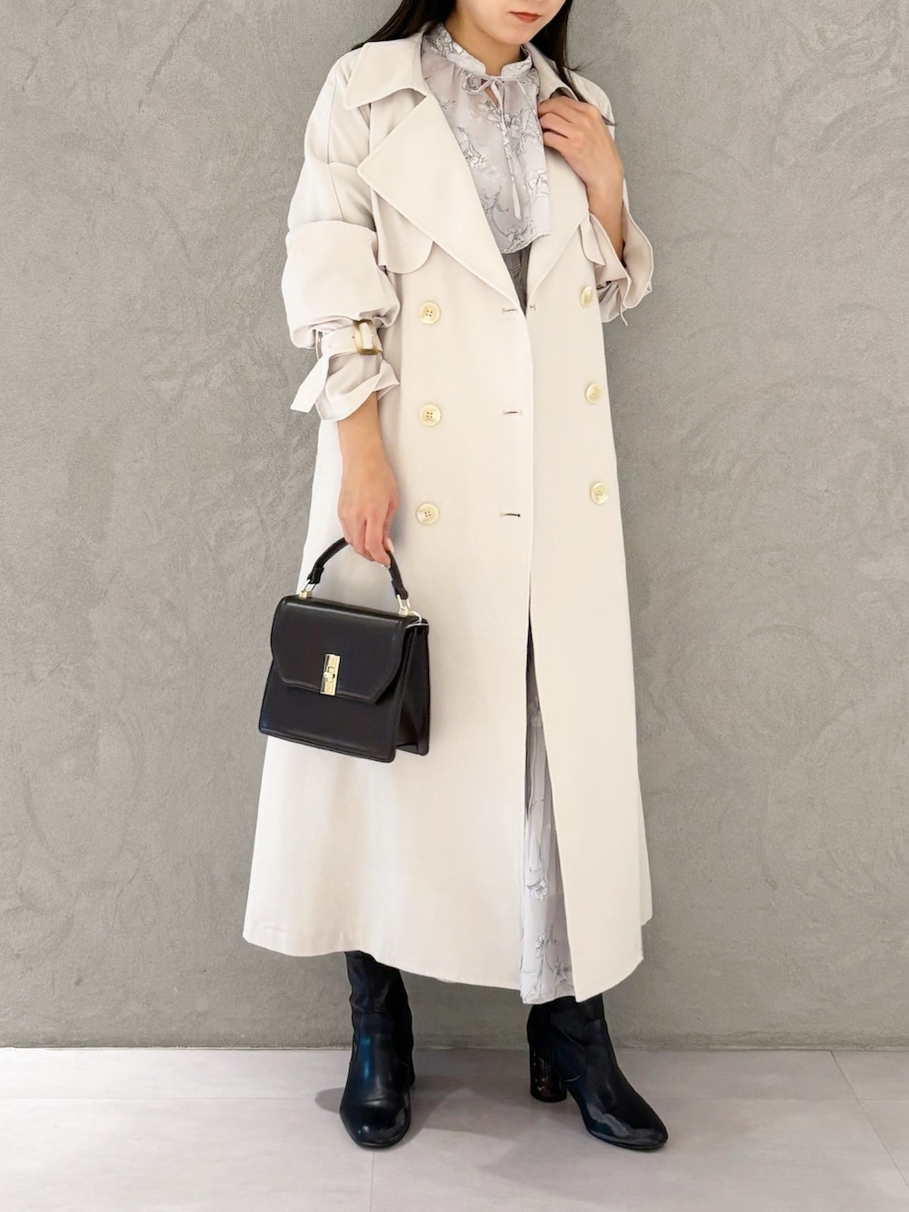 ピンク系のワンピース、ブラック系のブーツ、ブラウン系のハンドバッグを着用したレディースの春コーディネートの4枚目の写真