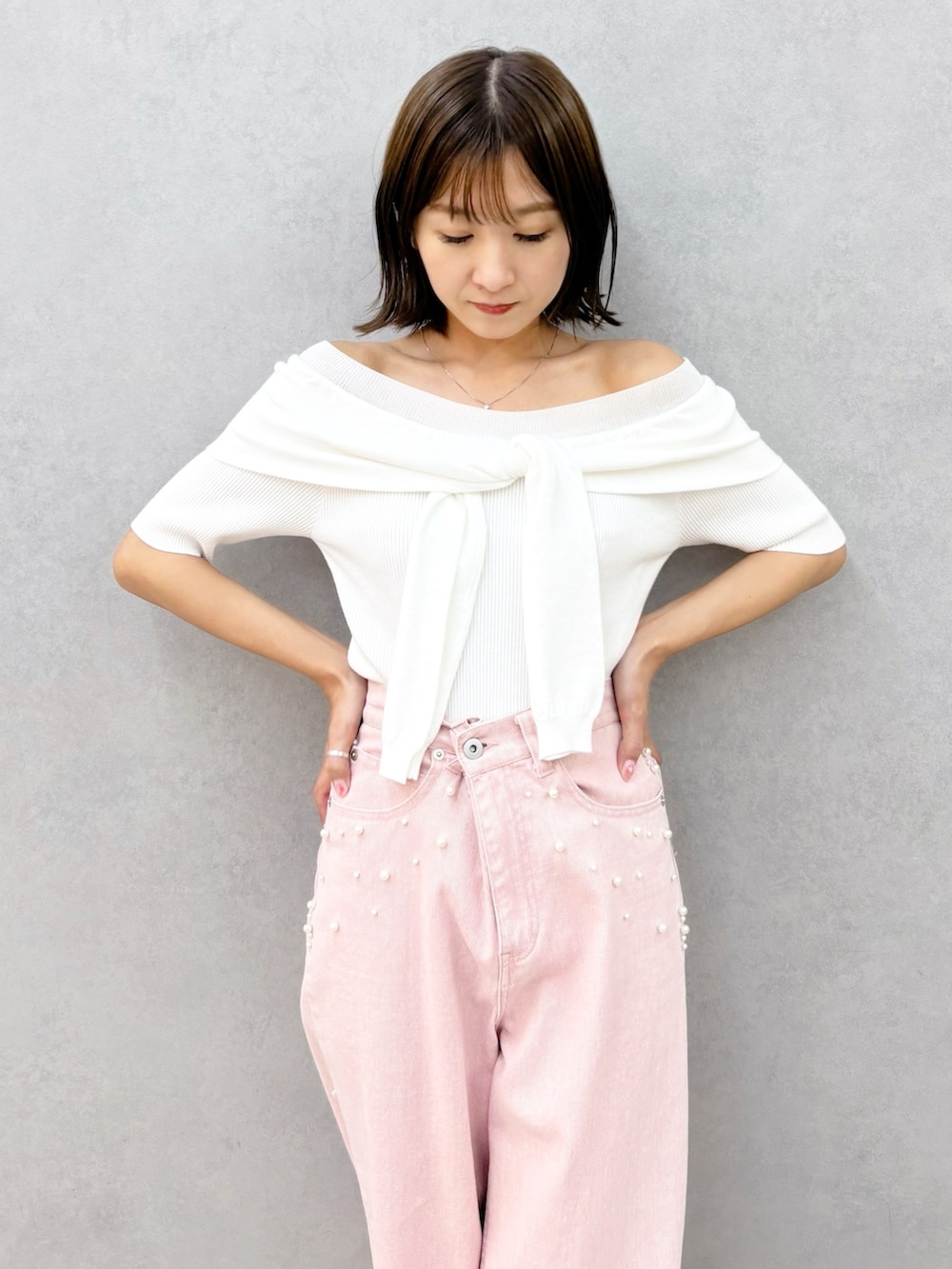 ピンク系のデニムパンツ、その他のサンダル、ホワイト系のニット/セーターを着用したレディースの春コーディネートの7枚目の写真