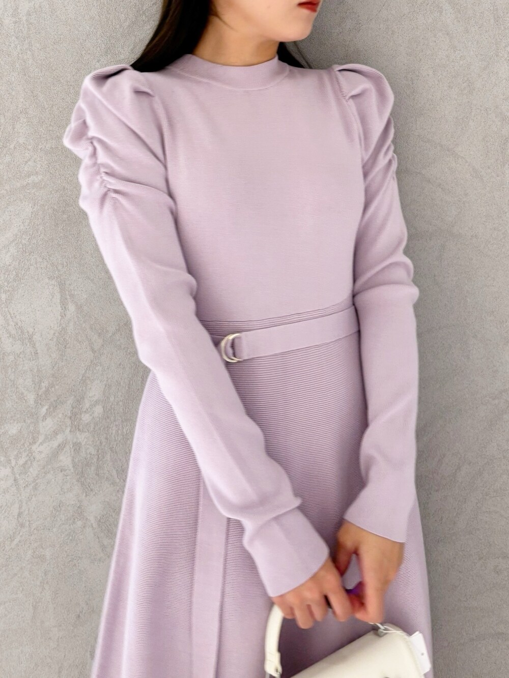 ホワイト系のショルダーバッグ、ブラック系のブーツ、パープル系のワンピースを着用したレディースの冬コーディネートの5枚目の写真