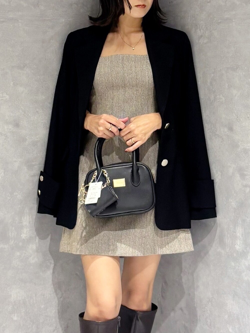 ブラウン系のワンピース、ブラウン系のブーツ、ブラック系のハンドバッグを着用したレディースの秋コーディネートの6枚目の写真