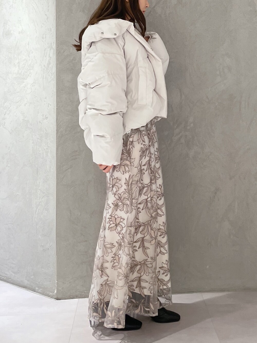 ホワイト系のダウンジャケット/コート、ホワイト系のニット/セーター、ピンク系のスカートを着用したレディースの冬コーディネートの3枚目の写真