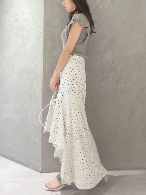 ホワイト系のハンドバッグ、グリーン系のサンダル、ホワイト系のスカートを着用したレディースの春コーディネートの4枚目の写真