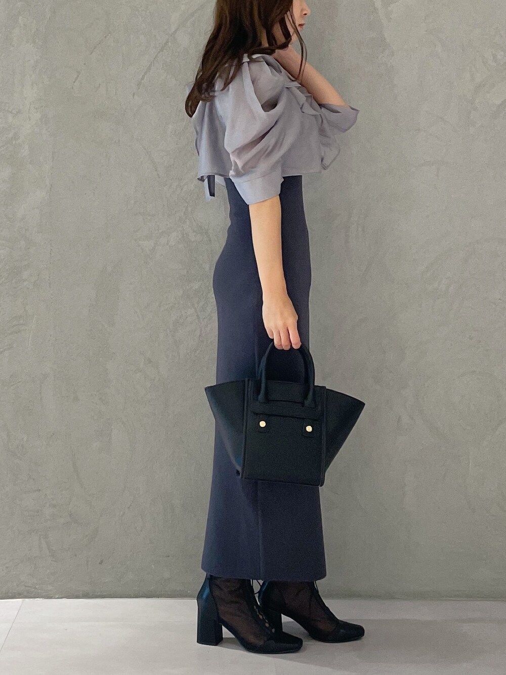 ブラック系のトートバッグ、グレー系のワンピース、ブラック系のブーツを着用したレディースの夏コーディネートの2枚目の写真