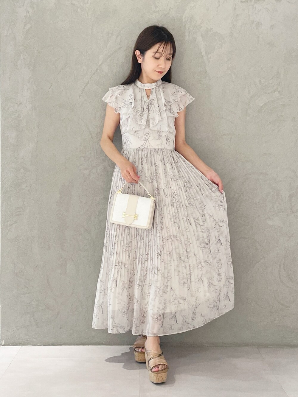 ホワイト系のハンドバッグ、ブラウン系のサンダル、ピンク系のワンピースを着用したレディースの春コーディネートの4枚目の写真