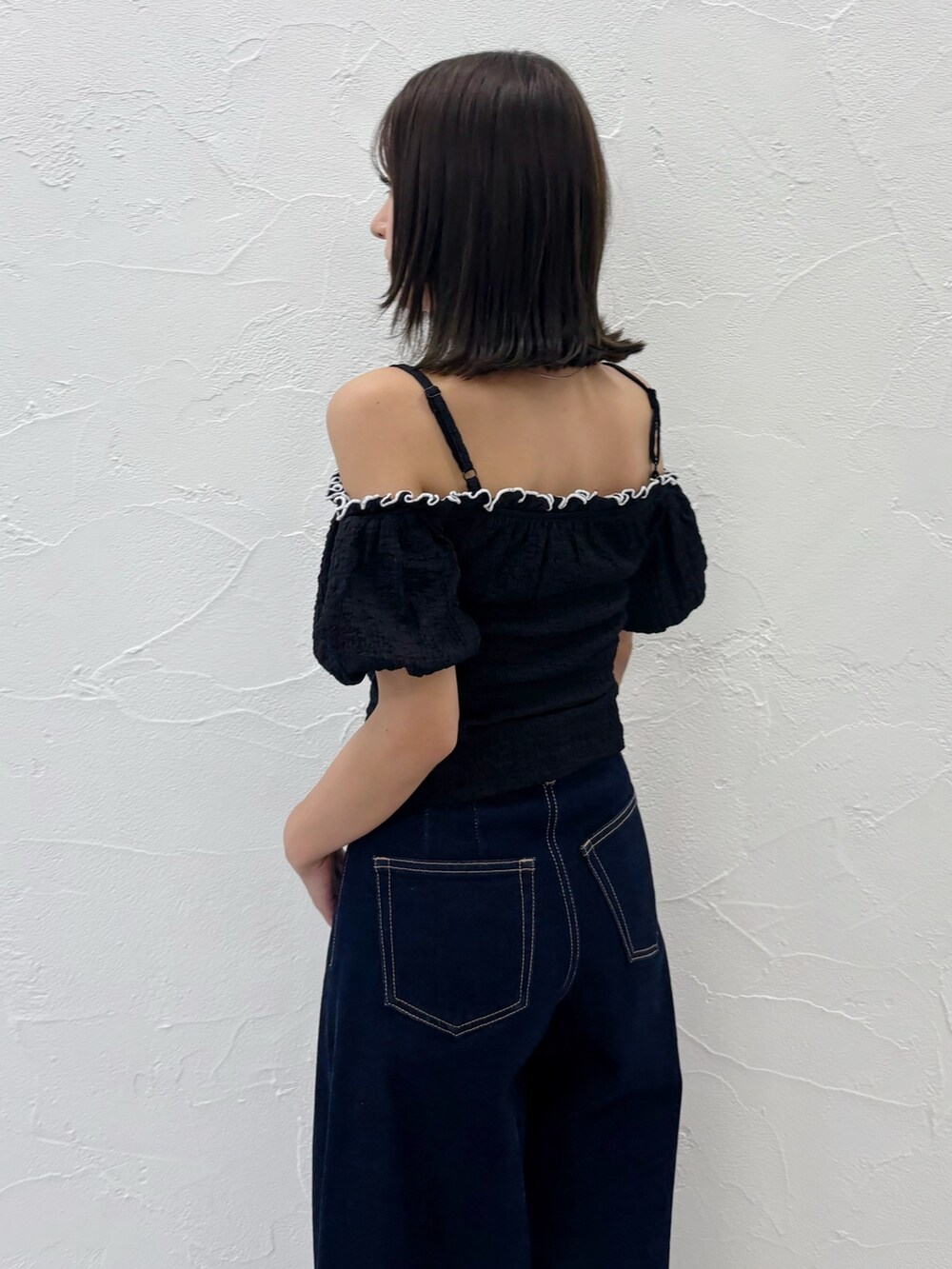 ブルー系のデニムパンツ、ホワイト系のサンダル、ブラック系のTシャツ/カットソーを着用したレディースの夏コーディネートの5枚目の写真