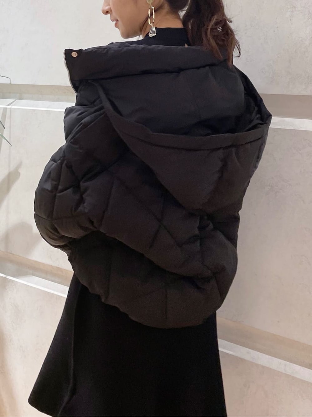 ブラック系のブルゾン、ブラック系のワンピース、ブラック系のブーツを着用したレディースの冬コーディネートの3枚目の写真