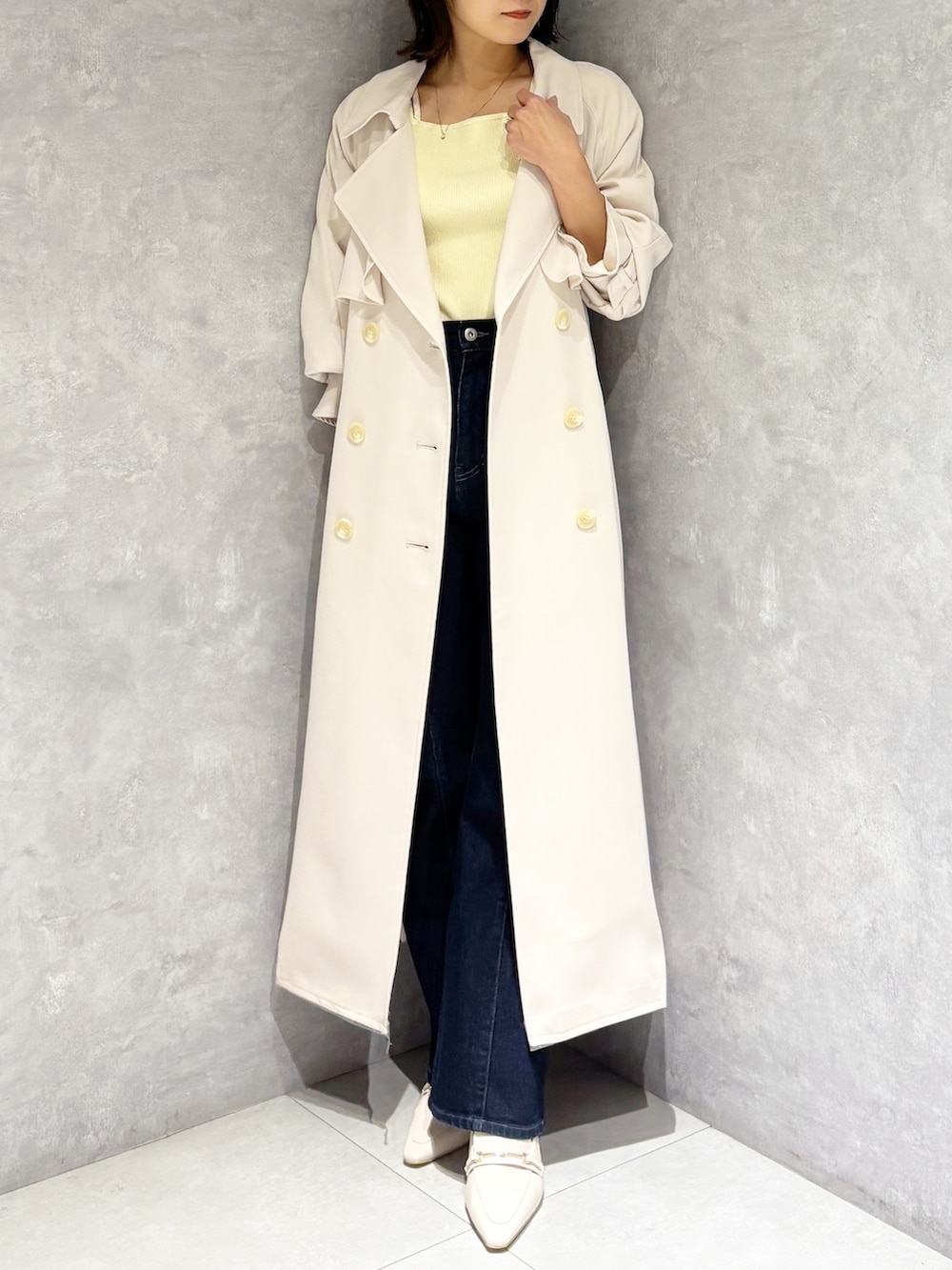 ブルー系のデニムパンツ、ホワイト系のパンプス、イエロー系のニット/セーターを着用したレディースの冬コーディネートの5枚目の写真