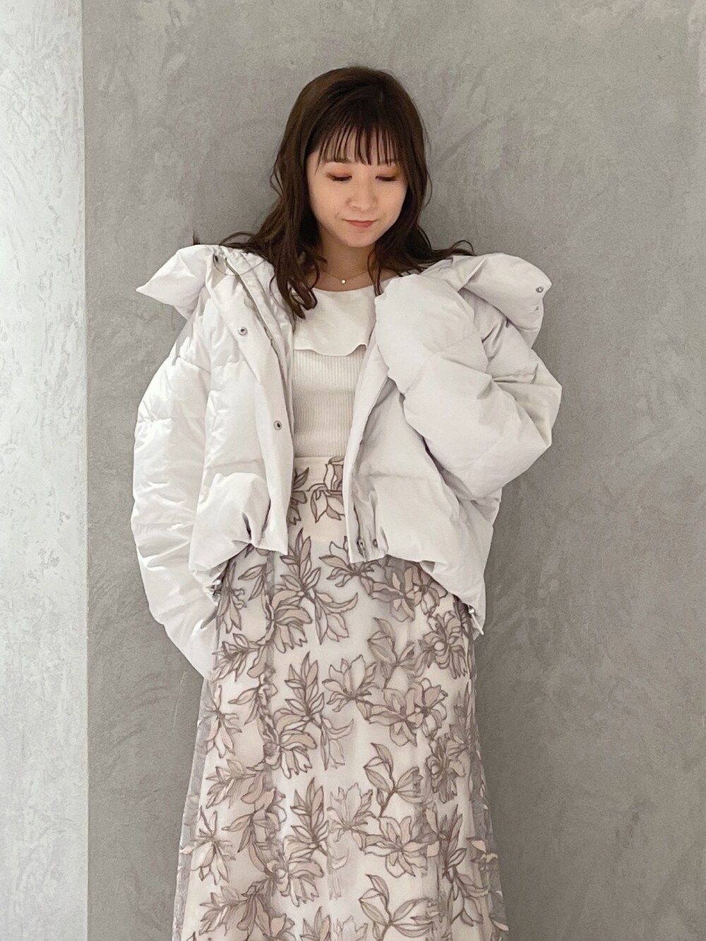 ホワイト系のダウンジャケット/コート、ホワイト系のニット/セーター、ピンク系のスカートを着用したレディースの冬コーディネートの6枚目の写真