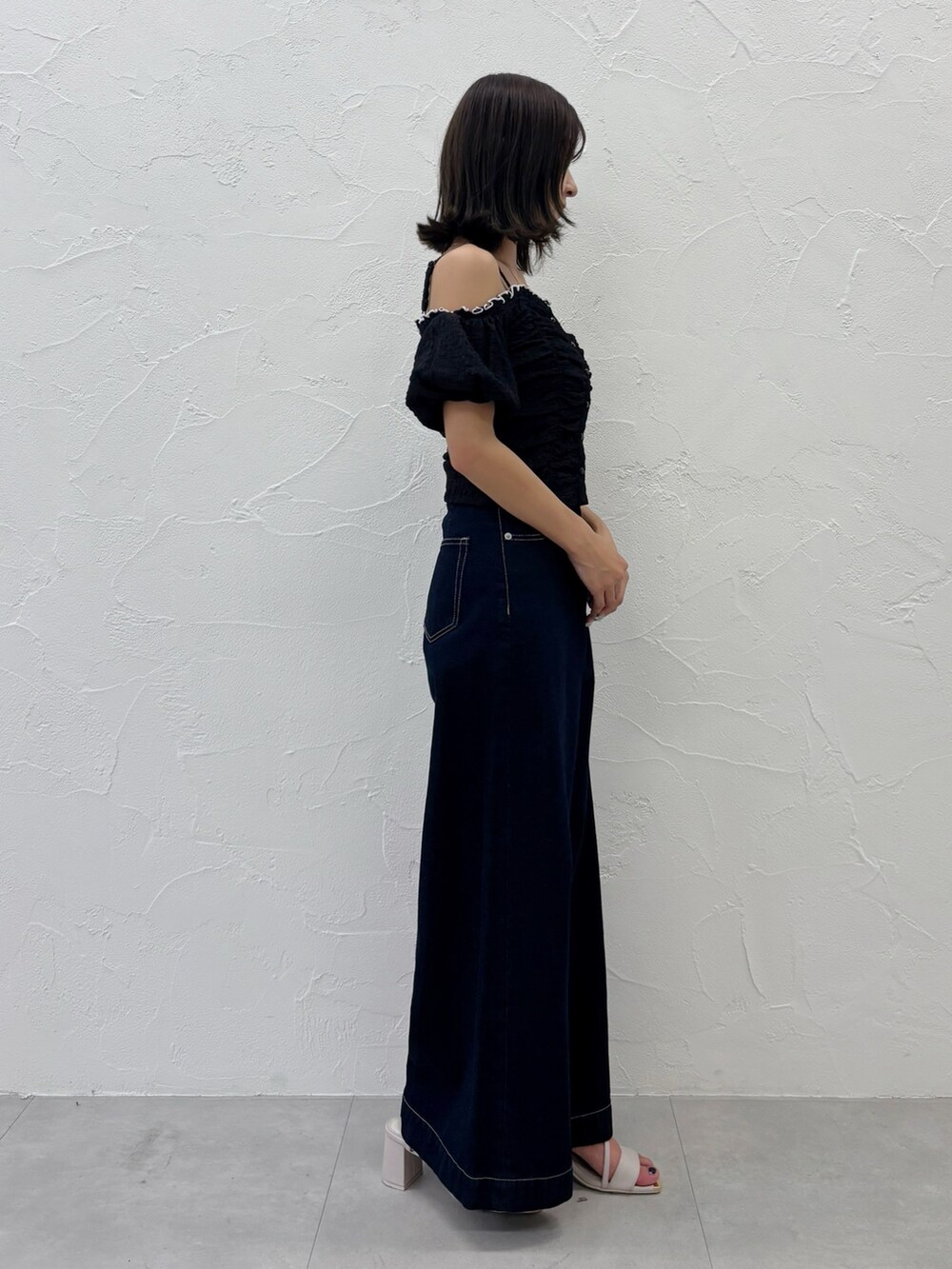 ブルー系のデニムパンツ、ホワイト系のサンダル、ブラック系のTシャツ/カットソーを着用したレディースの夏コーディネートの9枚目の写真