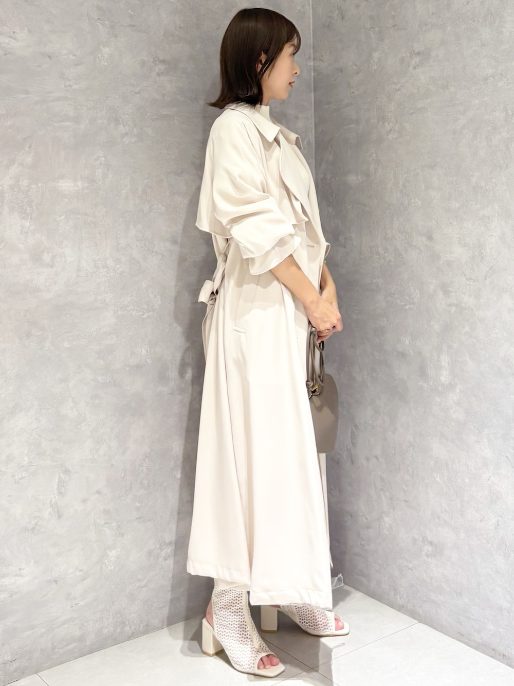ホワイト系のワンピース、ホワイト系のブーツ、ホワイト系のトレンチコートを着用したレディースの春コーディネートの4枚目の写真