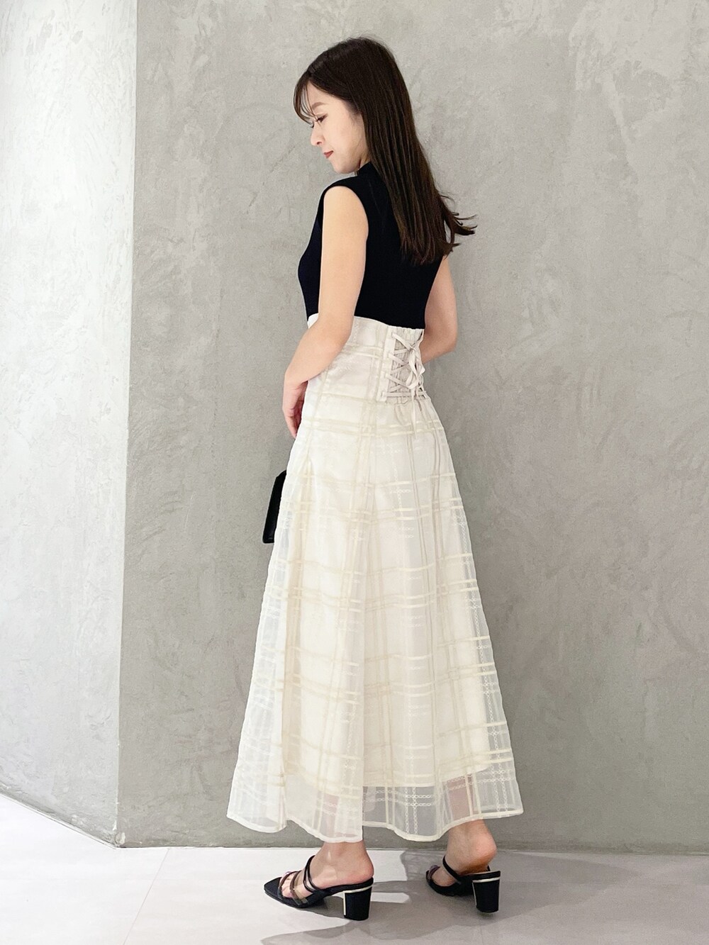 ブラック系のショルダーバッグ、ブラック系のサンダル、ブラック系のワンピースを着用したレディースの春コーディネートの2枚目の写真