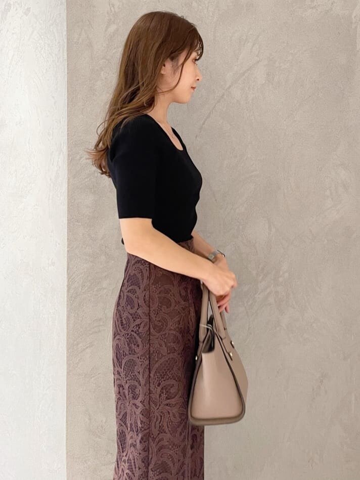 ブラウン系のハンドバッグ、ブラック系のニット/セーター、ブラック系のブーツを着用したレディースの夏コーディネートの3枚目の写真