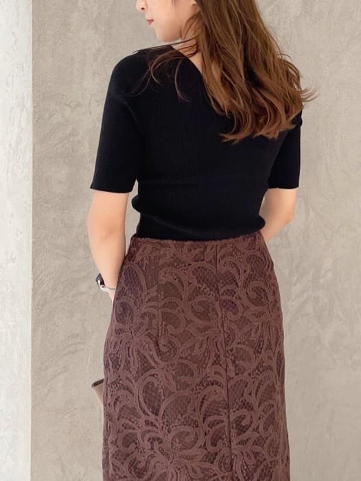 ブラウン系のハンドバッグ、ブラック系のニット/セーター、ブラック系のブーツを着用したレディースの夏コーディネートの5枚目の写真