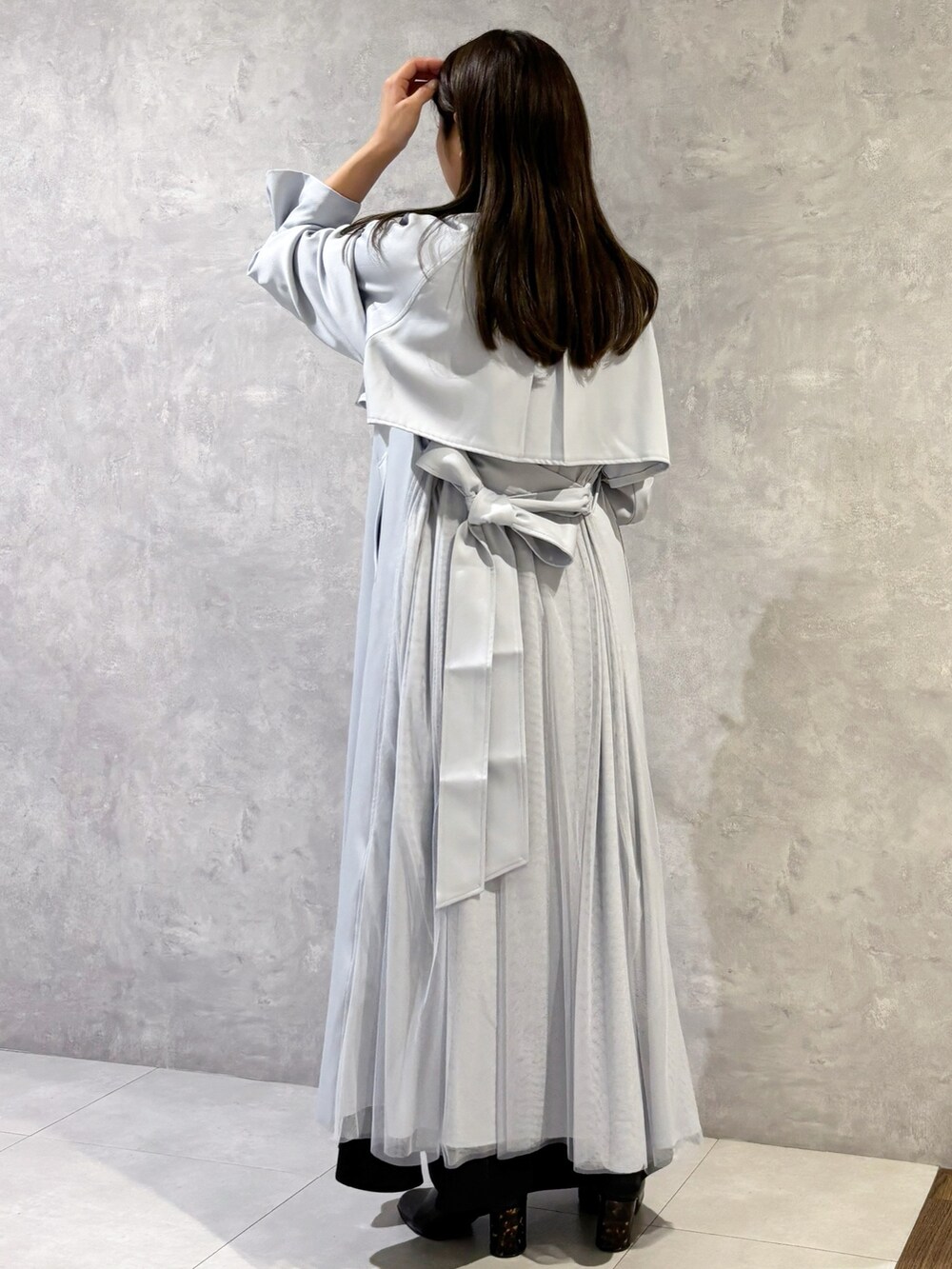 ブラック系のスカート、ブラック系のブーツ、ブラウン系のハンドバッグを着用したレディースの冬コーディネートの4枚目の写真