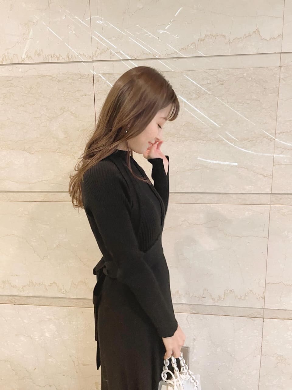 ブラック系のワンピース、ブラック系のその他シューズ、イエロー系のショルダーバッグを着用したレディースの冬コーディネートの4枚目の写真