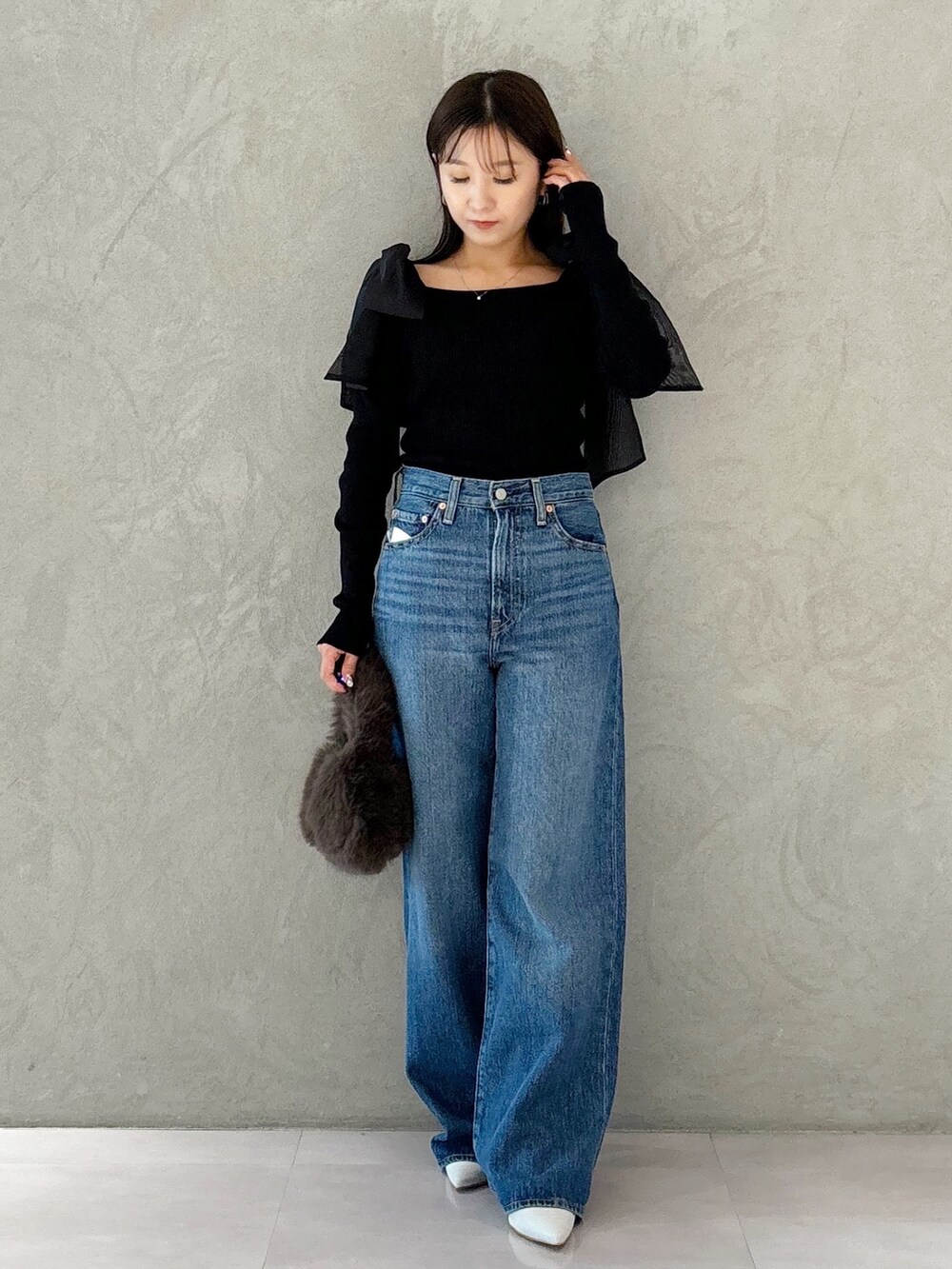 ブラウン系のハンドバッグ、シルバー系のパンプス、ブラック系のニット/セーターを着用したレディースの秋コーディネートの5枚目の写真