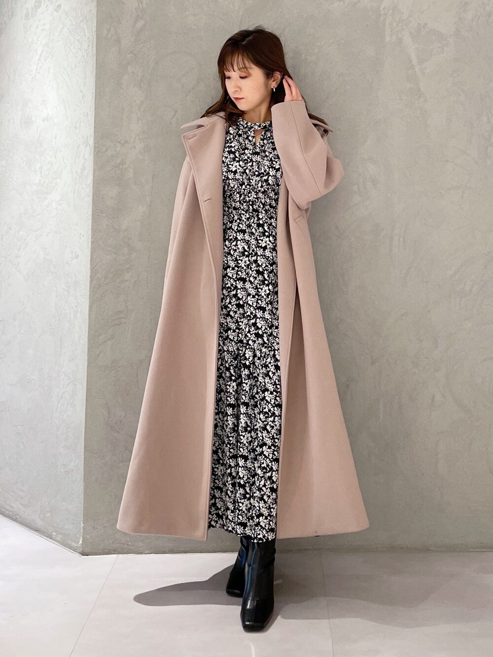 ブラック系のワンピース、ベージュ系のステンカラーコート、ブラック系のブーツを着用したレディースの秋コーディネートの6枚目の写真