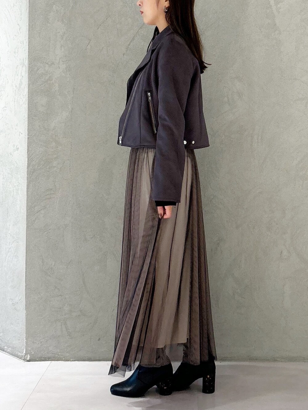 ブラック系のワンピース、ブラック系のブーツ、ブラウン系のハンドバッグを着用したレディースの秋コーディネートの5枚目の写真