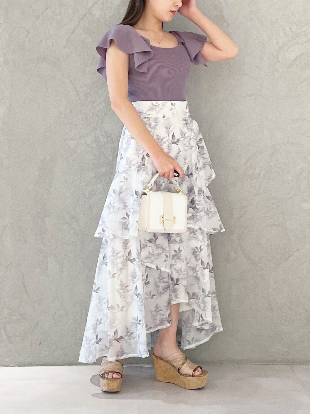 ホワイト系のハンドバッグ、パープル系のスカート、ブラウン系のサンダルを着用したレディースの春コーディネートの3枚目の写真