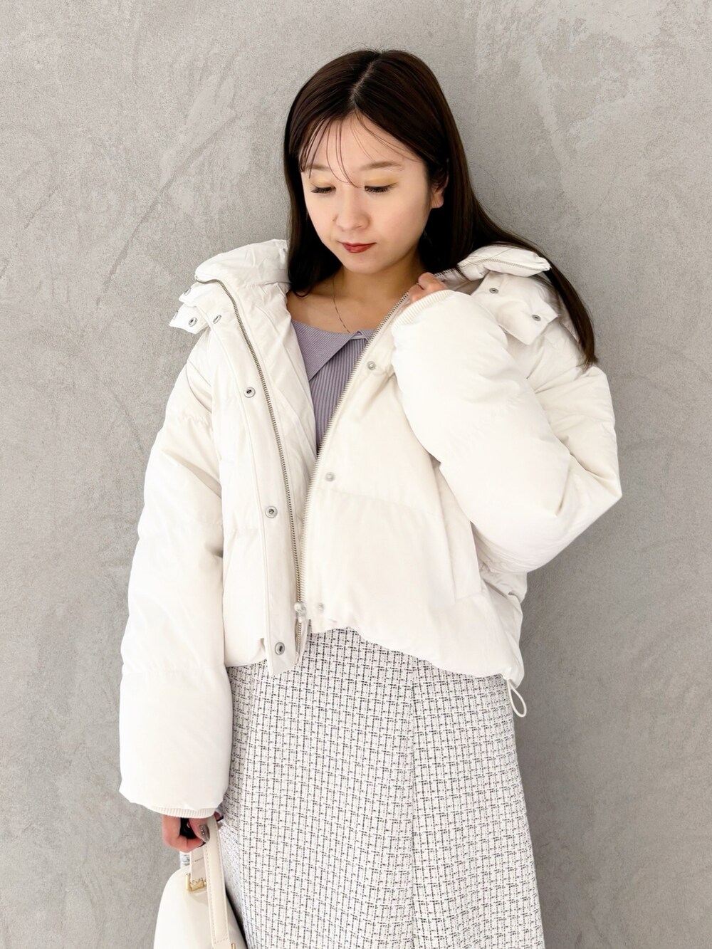 ホワイト系のスカート、ブラック系のブーツ、ホワイト系のハンドバッグを着用したレディースの冬コーディネートの5枚目の写真