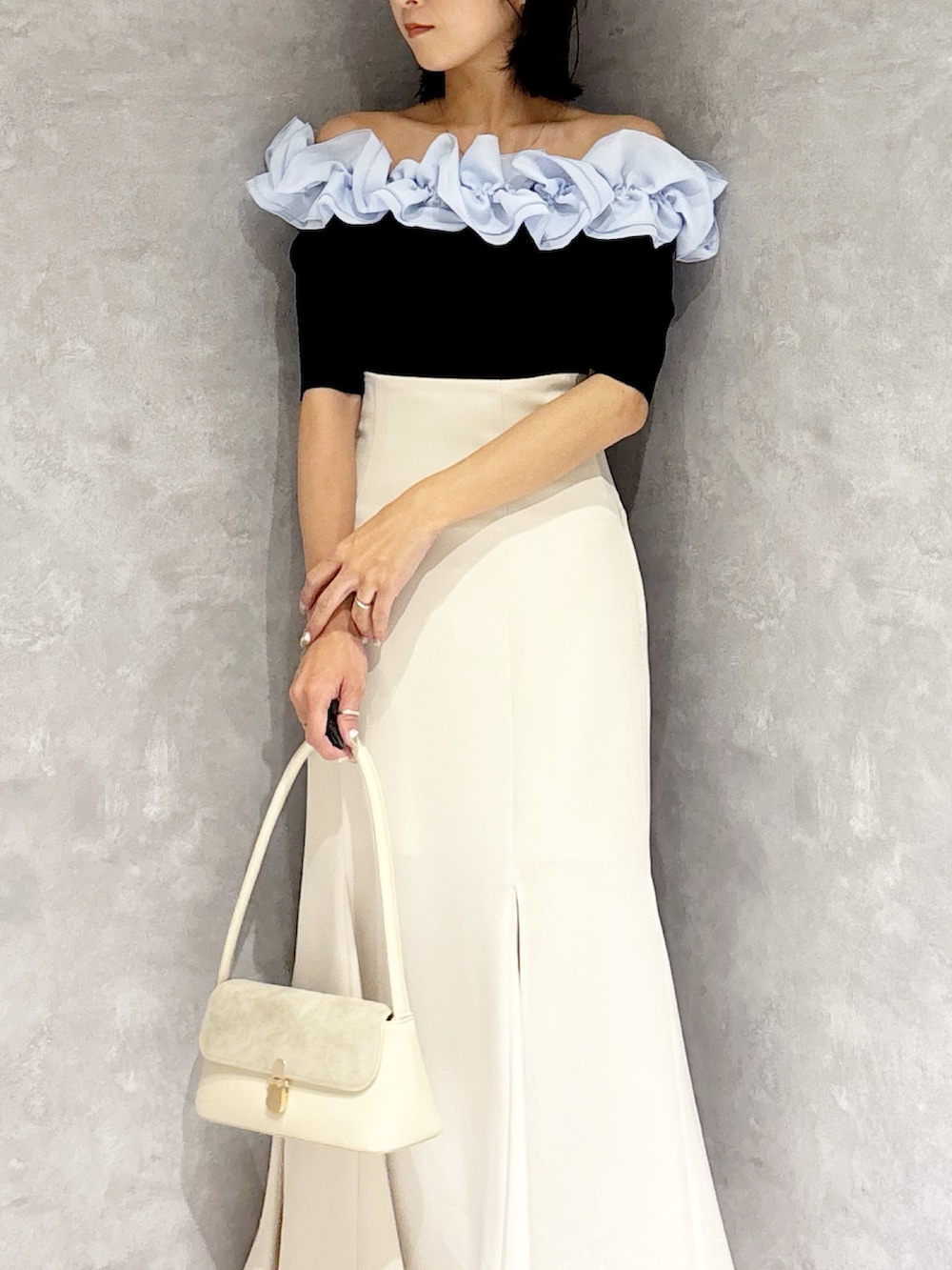 ホワイト系のスカート、ホワイト系のパンプス、ブルー系のニット/セーターを着用したレディースの春コーディネートの5枚目の写真